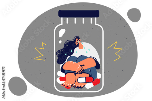 Tearful woman sits in antidepressant jar being held hostage by addictive pills to treat depression