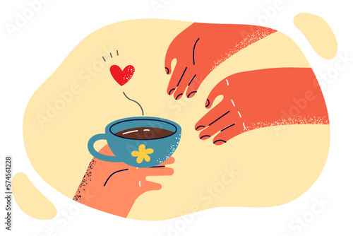 Hand passes freshly brewed coffee to another person for romantic courtship during love relationship