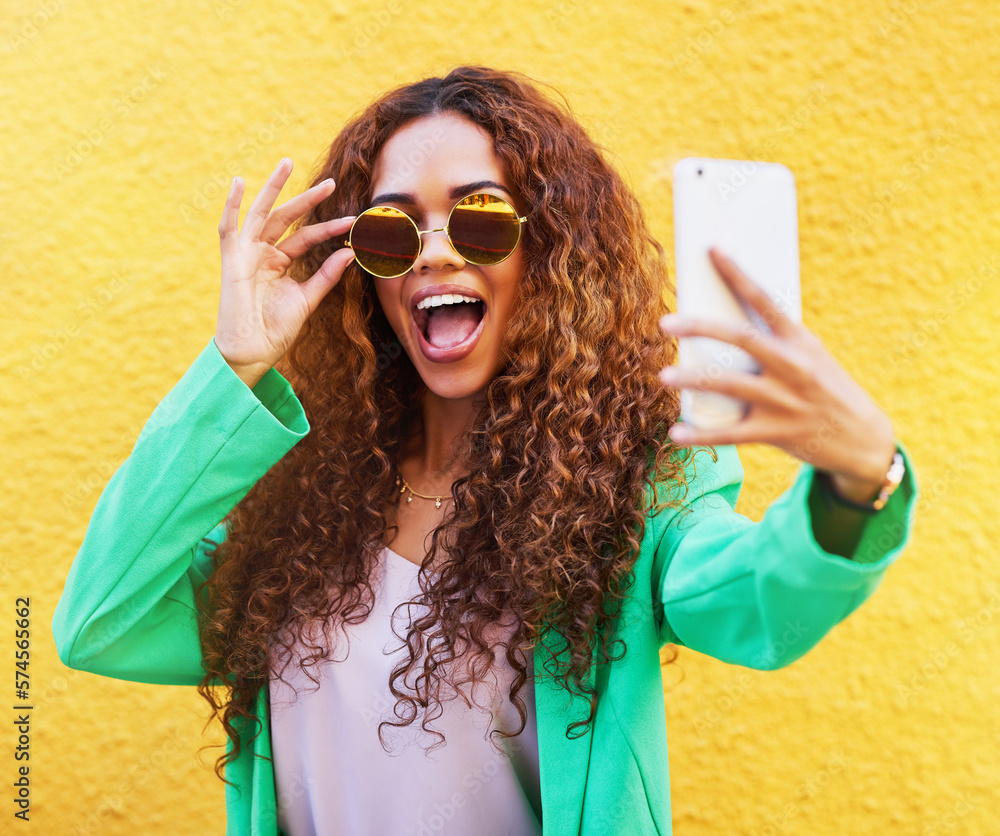 Selfie, fashion and woman with sunglasses on yellow background, color wall and gen z backdrop. Happy young female, trendy style and take profile picture on social media, green clothes and curly hair - obrazy, fototapety, plakaty 