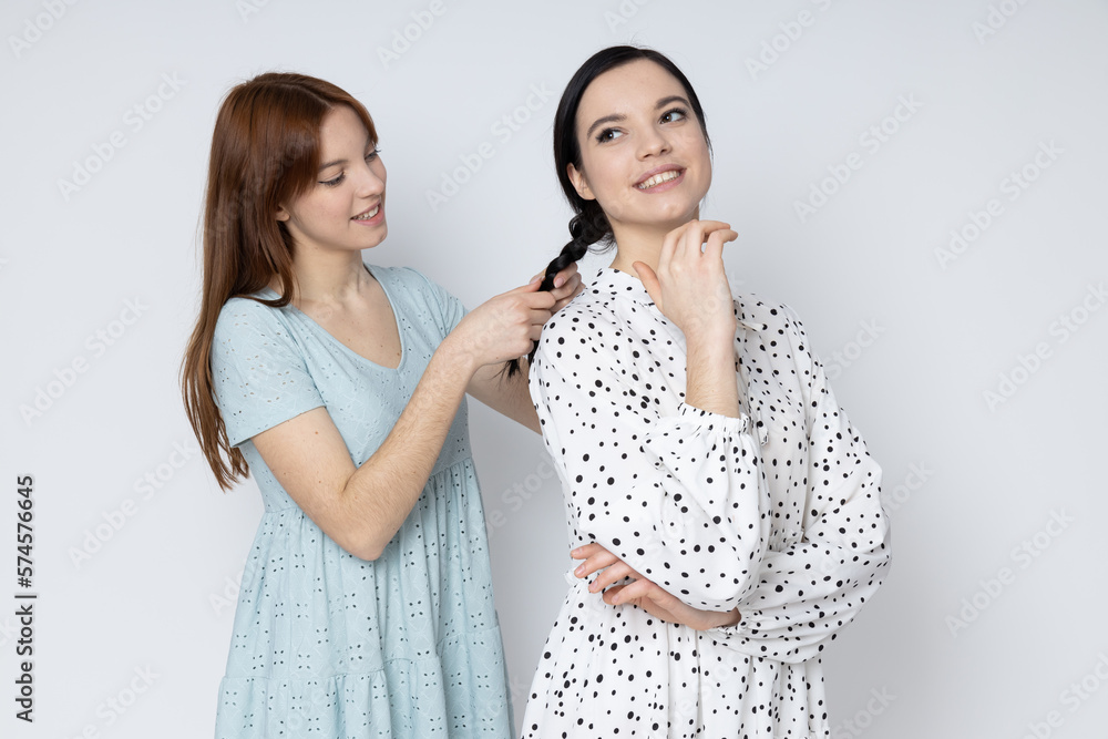 Two beautiful young women, sisters - twins on white background Two beautiful young women, sisters - twins on white background