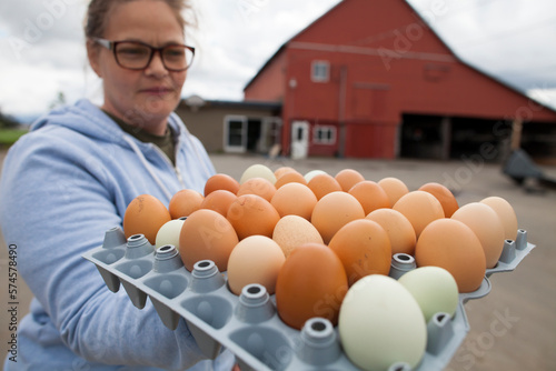 Female farmer holding full egg carton outdoors, Chilliwack, British Columbia, Canada photo