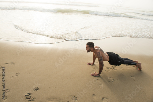 Muscular man exercising alone on sandy beach, Hampton, New Hampshire, USA photo