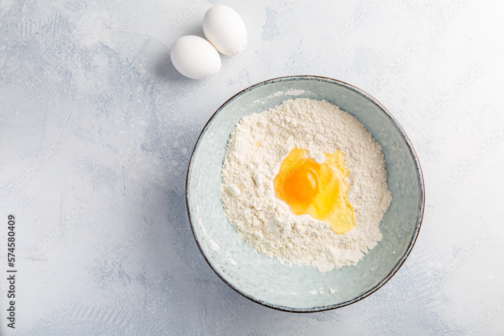 Flour with egg in bowl - cooking and baking ingredients Flour with egg in bowl - cooking and baking ingredients