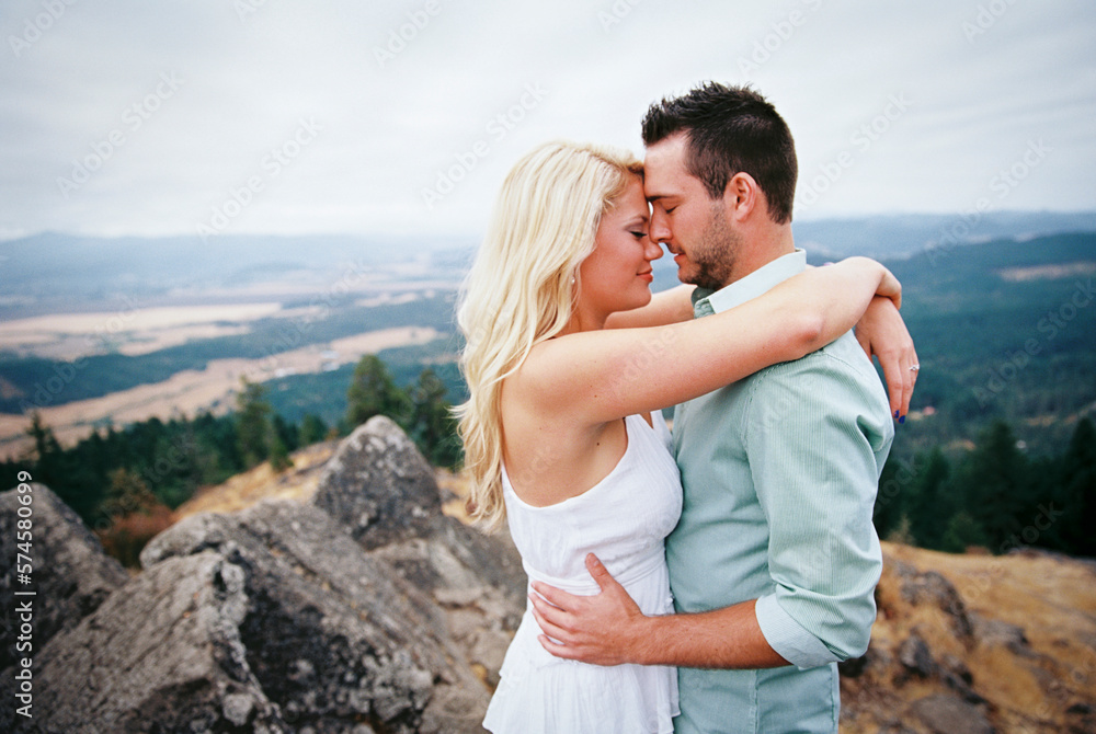 Portrait of young couple hugging on top of hill, Eugene, Oregon, USA Portrait of young couple hugging on top of hill, Eugene, Oregon, USA