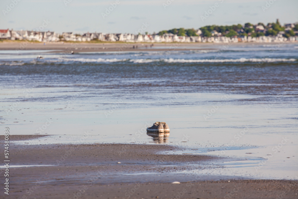 Sneakers on a sandy beach near the waterline. Sneakers on a sandy beach near the waterline.