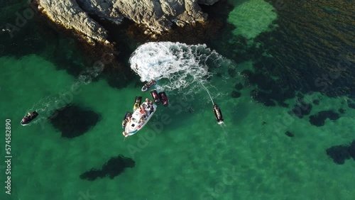 A man flies on a FlyBoard. Aerial top down view. Water extreme sport, azure summer sea with outdoors active people enjoying water sports. Flyboarding and seariding, Recreation and sports concepts. photo