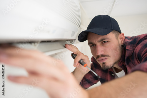 male worker checking the state of an airconditioner