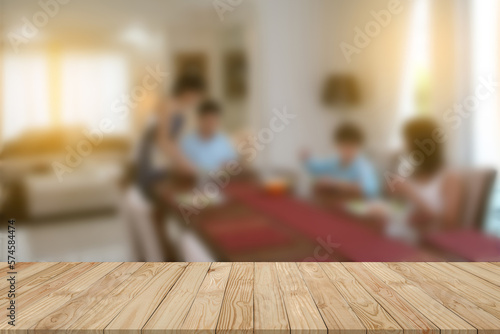 Beautiful pattern of perspective empty brown plank wooden board mockup display desk or counter with blurred background activity of 4 peoples as dad-mom-son-daughter have breakfast in cozy dining room