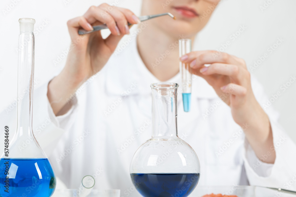 Fototapeta premium Young female research scientist puts sample