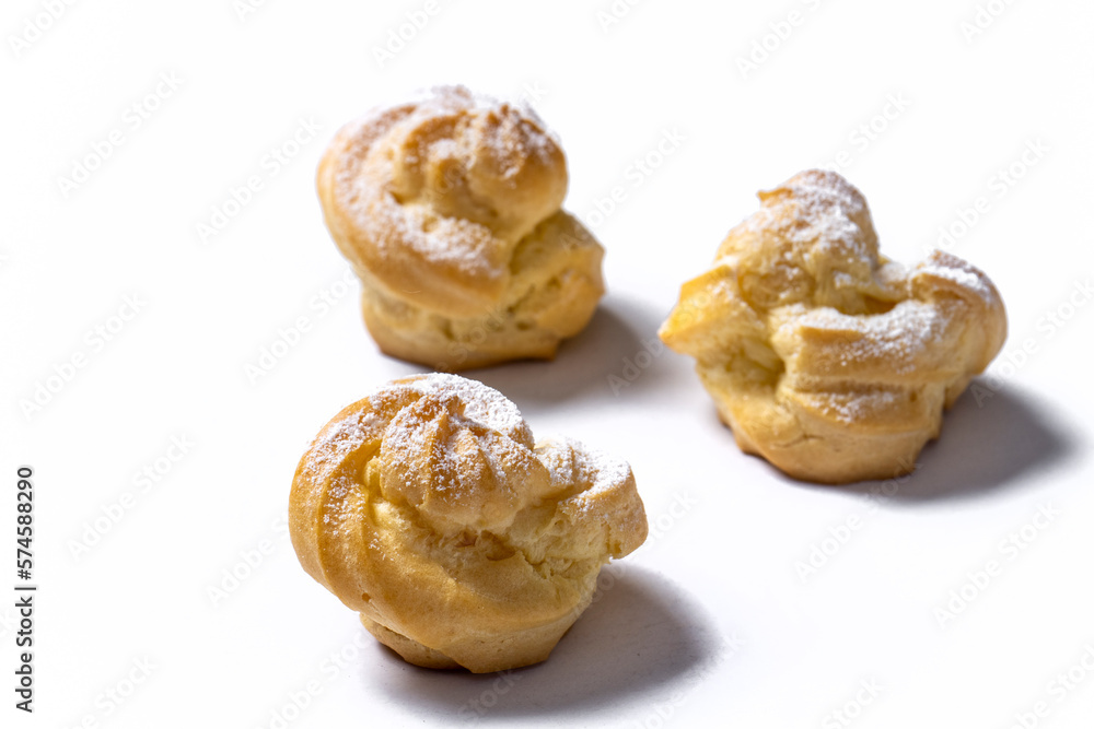 Decorating profiteroles with powdered sugar. Eclairs with icing sugar