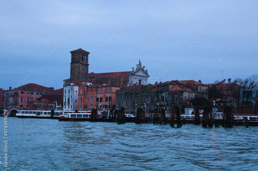 Scenic panoramic view of Venice in winter. Moored boats near colorful ancient buildings.  Winter drizzle morning in Venice. Famous touristic place and travel destination in Europe
