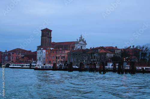 Scenic panoramic view of Venice in winter. Moored boats near colorful ancient buildings. Winter drizzle morning in Venice. Famous touristic place and travel destination in Europe