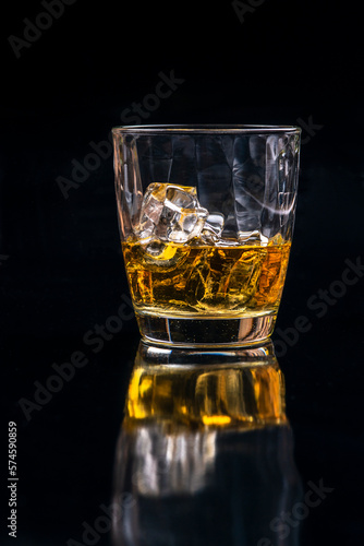 Whisky glass with ice on black background