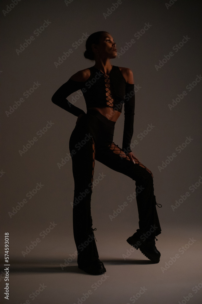 Stylish woman in a sexy black suit with lacing. Fashion photoshoot. Stylish woman in a sexy black suit with lacing. Fashion photoshoot.