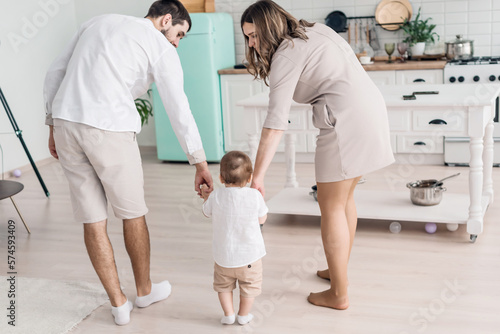 Happy parents with little son on modern kitchen, family enjoying weekend at home together