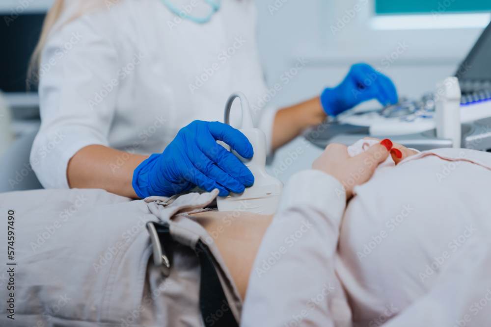 The doctor's hand with an ultrasound scanner in the hospital during the examination of the patient. The doctor's hand with an ultrasound scanner in the hospital during the examination of the patient.