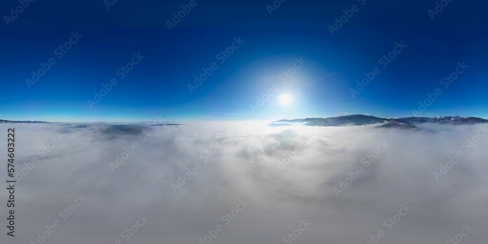 360 panorama aerial drone view above the sea of clouds and surrounded by mountains with a deep blue sky and a beautiful radiant sun, a fairy tale-like dreamy cotton bed at altitude