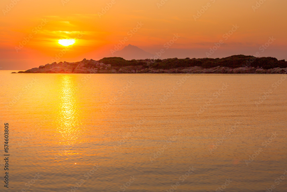 Mount Athos in Greece at sunset, bright sunrise in the early summer morning, orange sun, background