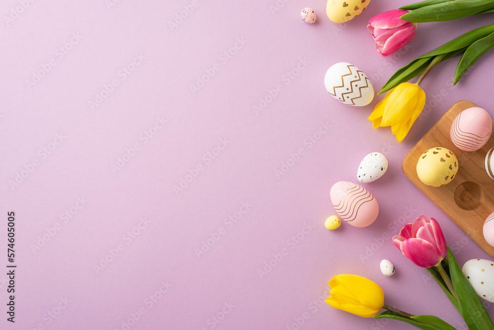 Easter decor concept. Top view photo of colorful easter eggs in wooden holder yellow and pink tulips on isolated pastel violet background with empty space