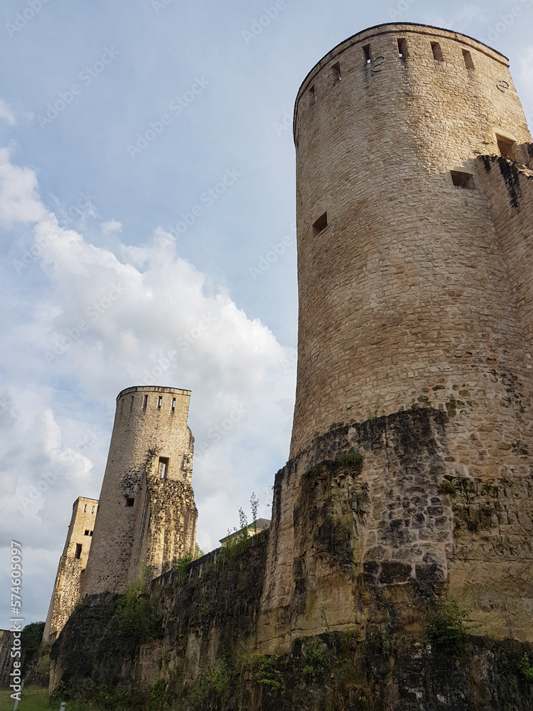 Old stone towers and wall with partly cloudy sky in Luxembourg City