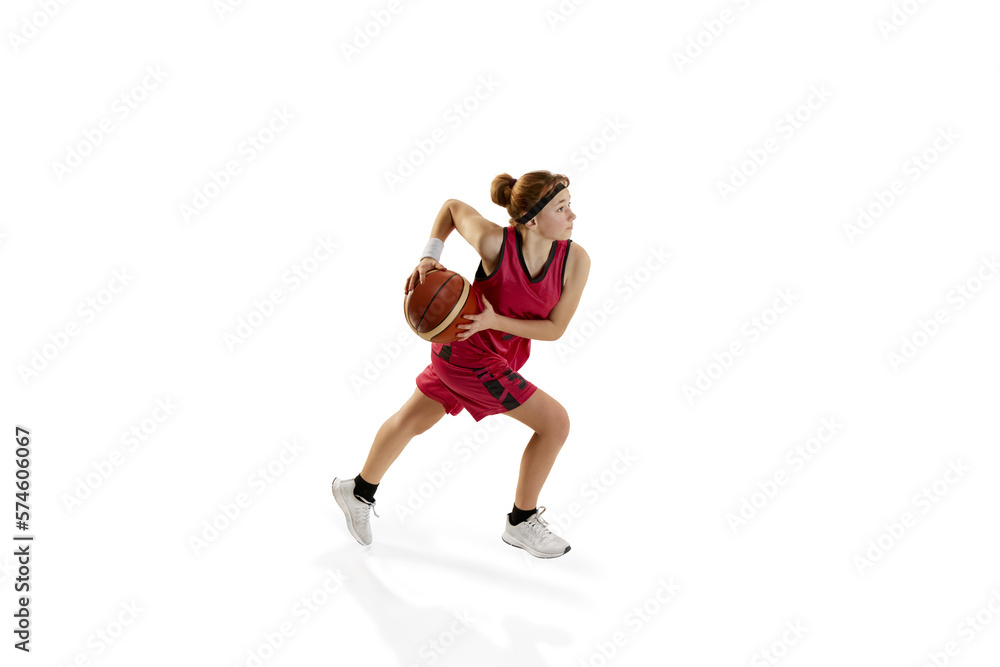 Concentrated active teen girl, basketball player in motion, playing isolated over white studio background. Winning game. Concept of sportive lifestyle, active hobby, health, endurance, competition