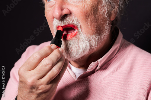senior man paints his lips red
