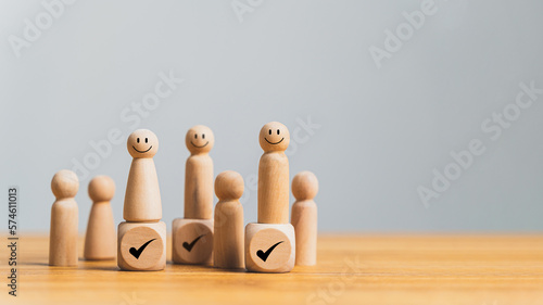Wooden model of a human figure with a right check sign, representing human resource management concepts such as talent management, recruitment, and retention photo