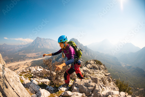 hiking in the mountains. a girl with a backpack walks along a mountain range. climbing and hiking.