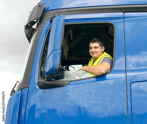 Cheerful man sitting in truck at steering wheel