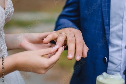 Bride putting the wedding ring to the groom