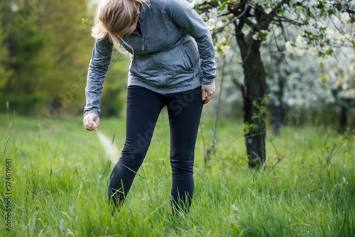 Принти на полотні Woman applying insect repellent against mosquito and tick on her leg before jogg