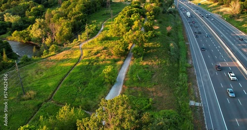 Timelapse of Busy Highway Flying Over to Trail in a Park Summertime photo