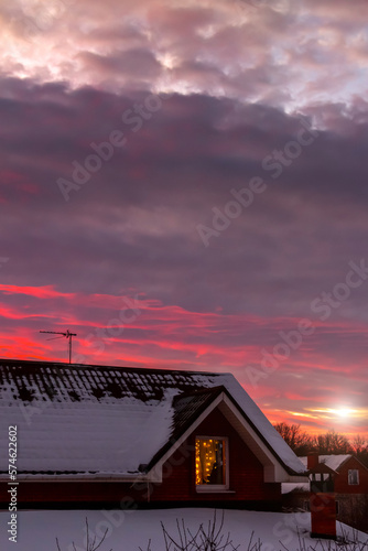 Beautiful sunset over the roof of a house in the village.