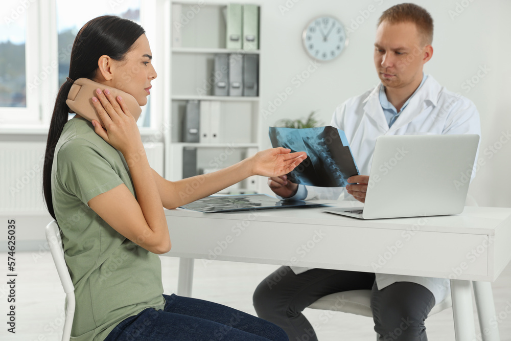 Doctor with neck MRI image consulting patient in clinic Doctor with neck MRI image consulting patient in clinic