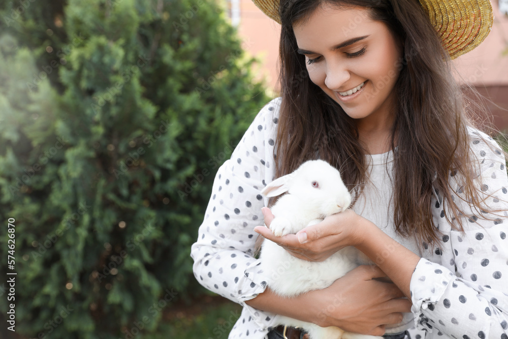 Happy woman with cute rabbit outdoors on sunny day. Space for text Happy woman with cute rabbit outdoors on sunny day. Space for text