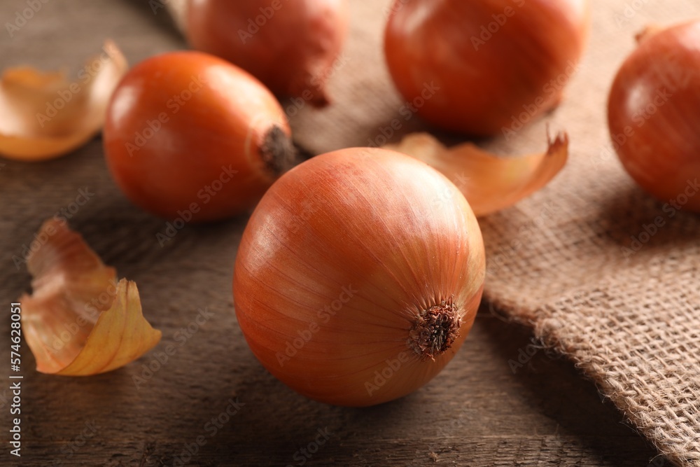 Many ripe onions on wooden table, closeup Many ripe onions on wooden table, closeup