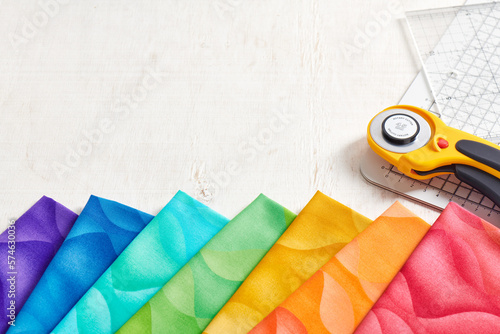 A set of fabrics for quilting in rainbow colors, quilting accessories, space for text