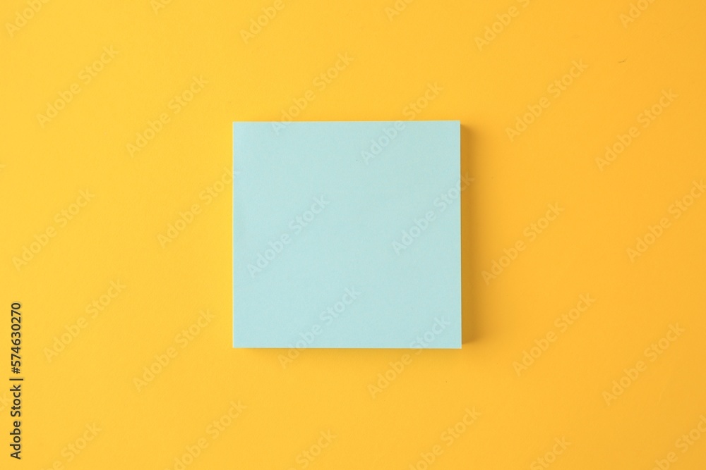 Blank paper note on orange background, top view Blank paper note on orange background, top view