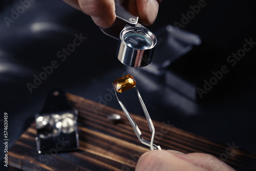 Professional jeweler working with gemstone, closeup view photo