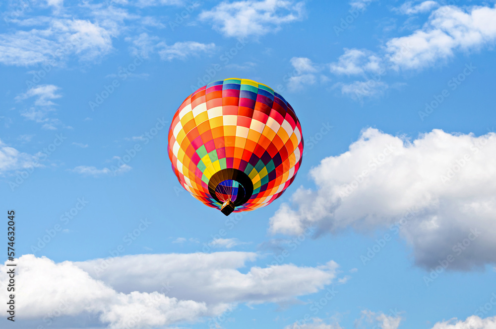 Fototapeta premium Colorful hot air balloon flying over blue sky with white clouds