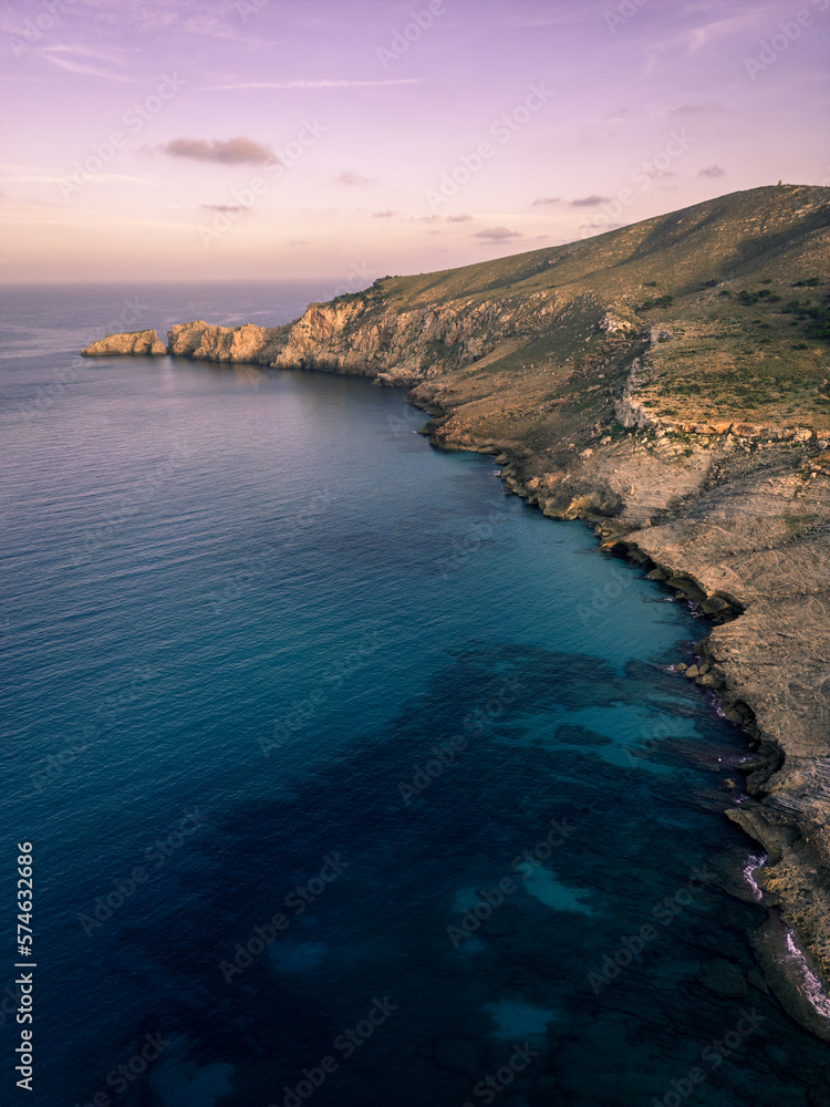 View over the shoreline of Mallorca, Spain, on a sunny afternoon in Summer with beautiful rock formations in the back during blue hour