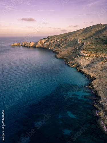 View over the shoreline of Mallorca, Spain, on a sunny afternoon in Summer with beautiful rock formations in the back during blue hour