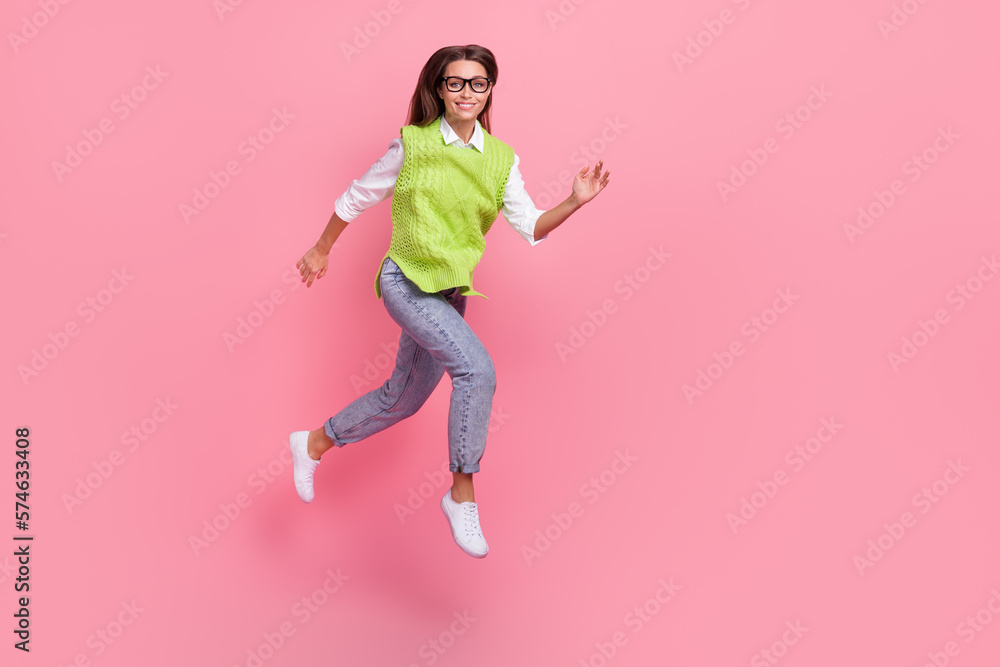 Full size photo of good mood nice adorable woman wear green waistcoat jeans shoes running at sale isolated on pink color background