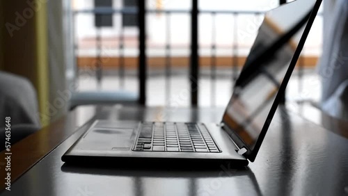 Female hands closing laptop computer on the table in the dark room