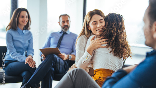 Canvas-taulu Young adult woman embracing and supporting friend during support group therapy session with diverse women