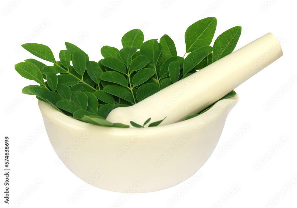 Edible moringa leaves in a mortar with pestle