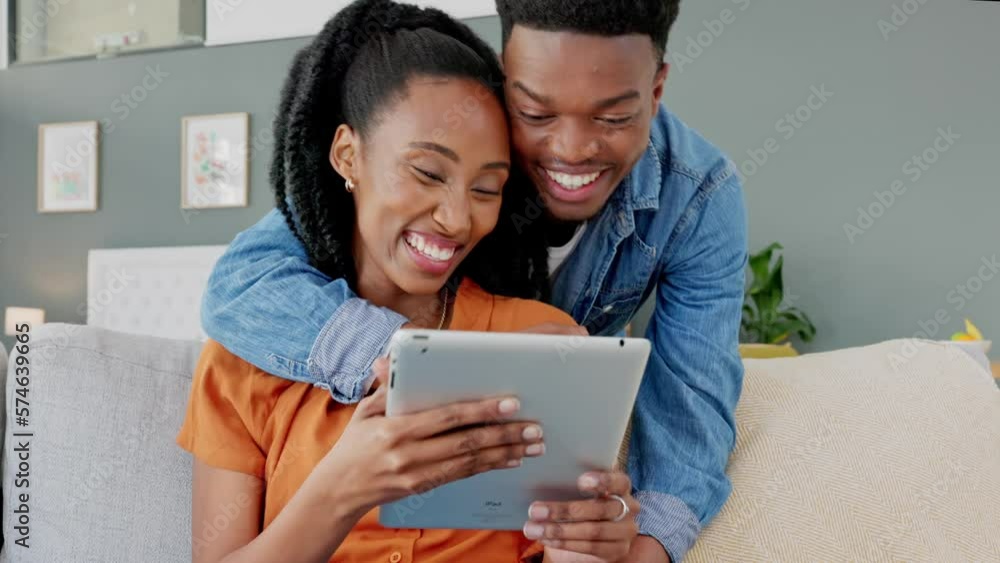 Happy couple networking on social media with a digital tablet while relaxing on the sofa together. Black man and woman on a funny website, meme or online app while sitting on a couch at home. Happy couple networking on social media with a digital tablet while relaxing on the sofa together. Black man and woman on a funny website, meme or online app while sitting on a couch at home.