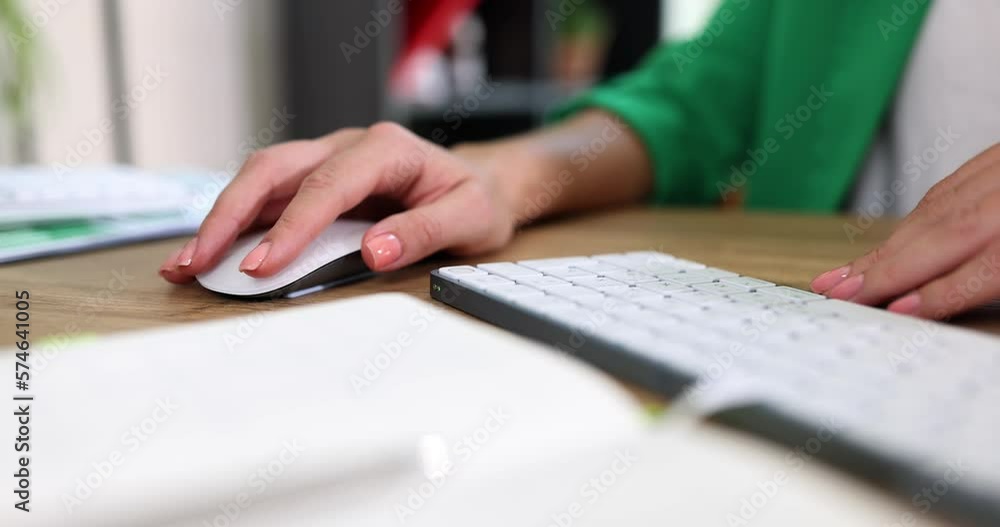 Closeup of business woman typing by hand on computer keyboard with mouse Closeup of business woman typing by hand on computer keyboard with mouse