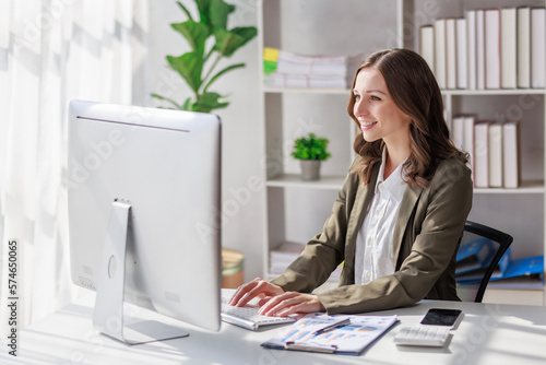 Concept of business investment or working woman,  Businesswoman wearing a suit sitting and working on analysis of business investment documents and using computer to analytic business data.