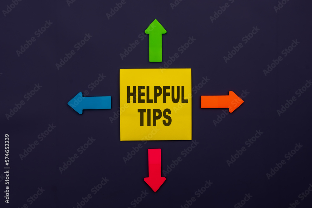 Helpful Tips - inscription of a yellow paper note next to an four colorful arrows over a dark blue background. Business, tips and tricks concept Helpful Tips - inscription of a yellow paper note next to an four colorful arrows over a dark blue background. Business, tips and tricks concept